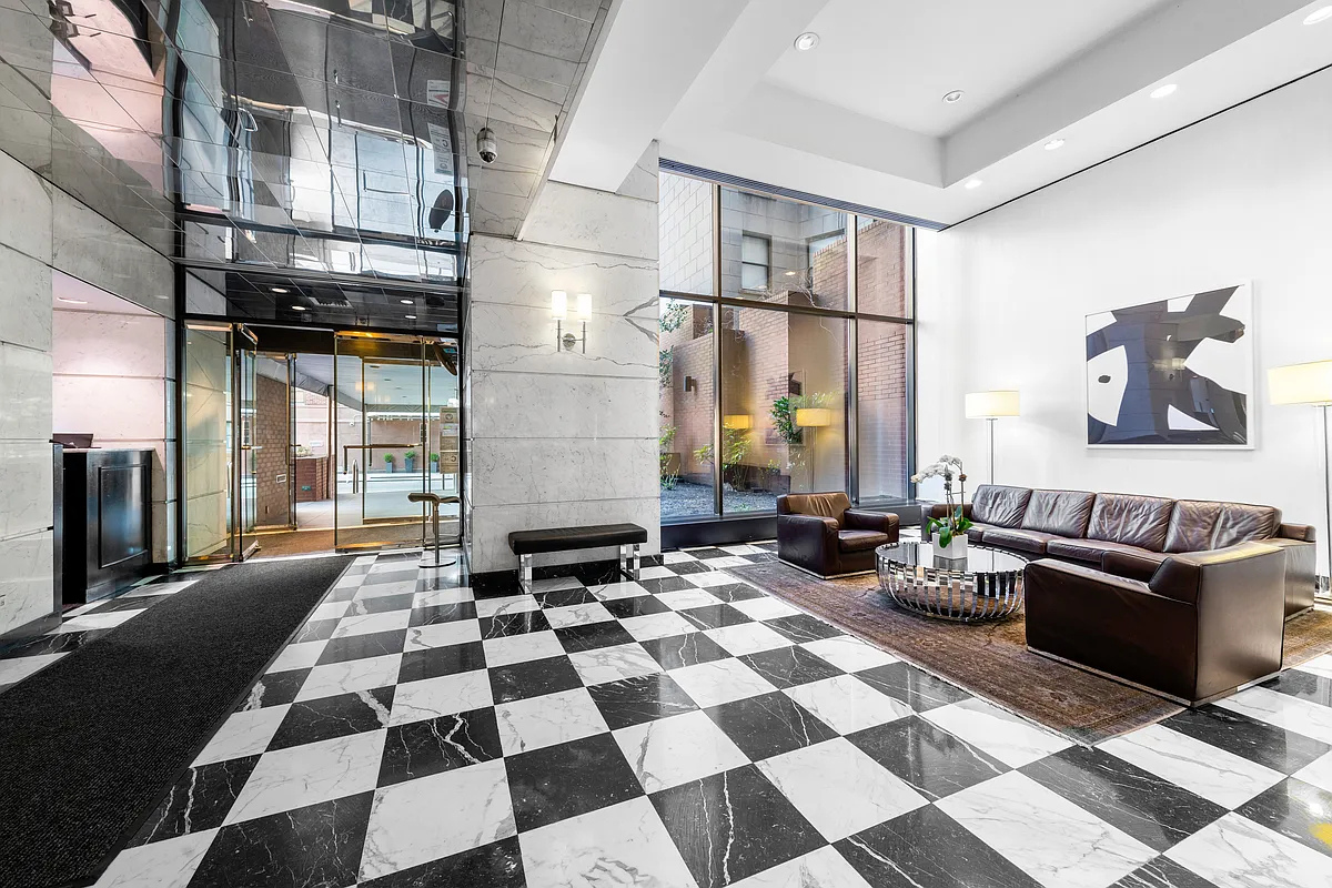 300 East 62nd Street, Unit 1001 Manhattan, NY 10065 - Photo 9 of 10 a living room with a black white checkered floor with couches chair and a coffee table