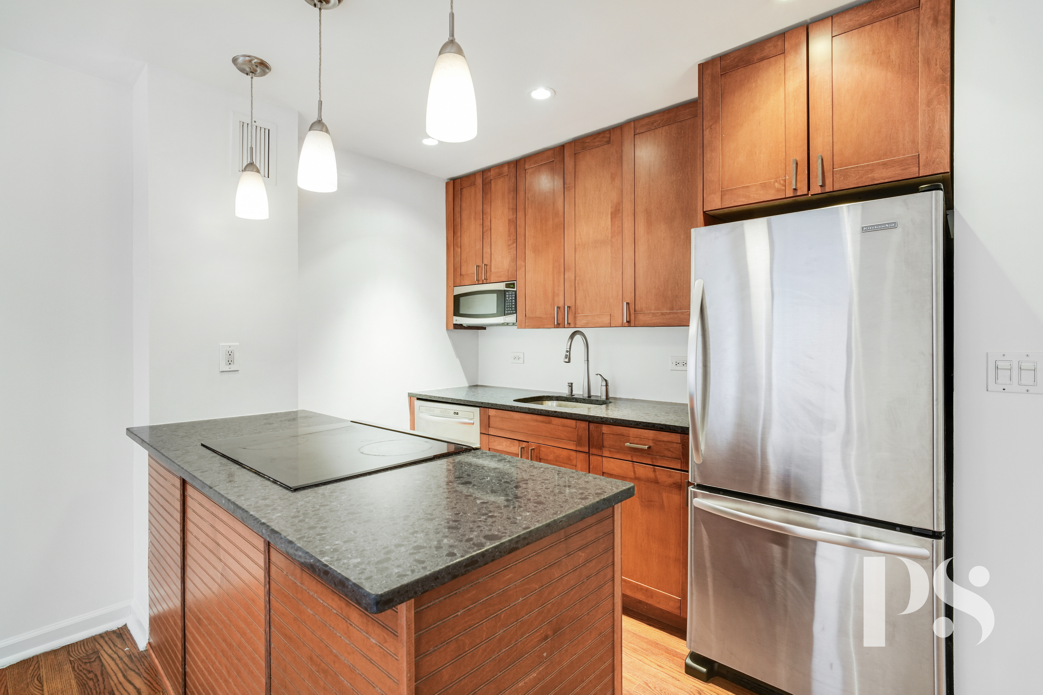 133 Barrow Street, Unit 1B Manhattan, NY 10014 - Photo 5 of 11 a kitchen with stainless steel appliances granite countertop a refrigerator a sink dishwasher a stove and white countertops with wooden floor