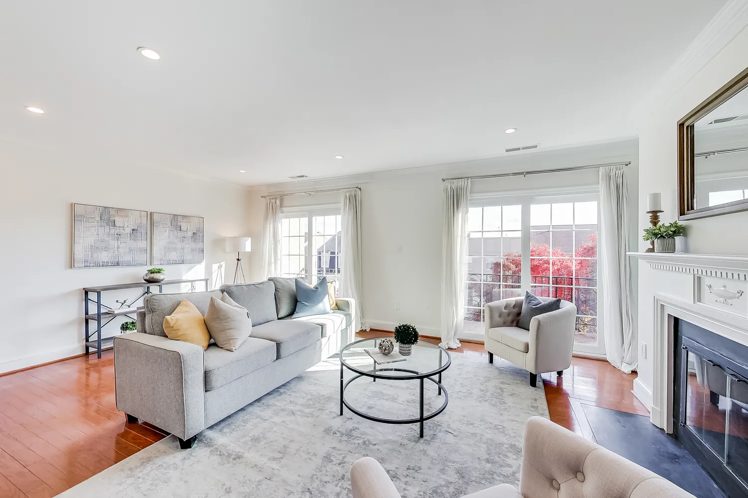a living room with furniture a fireplace and a large window