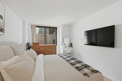 a bedroom with a large bed and a flat screen tv