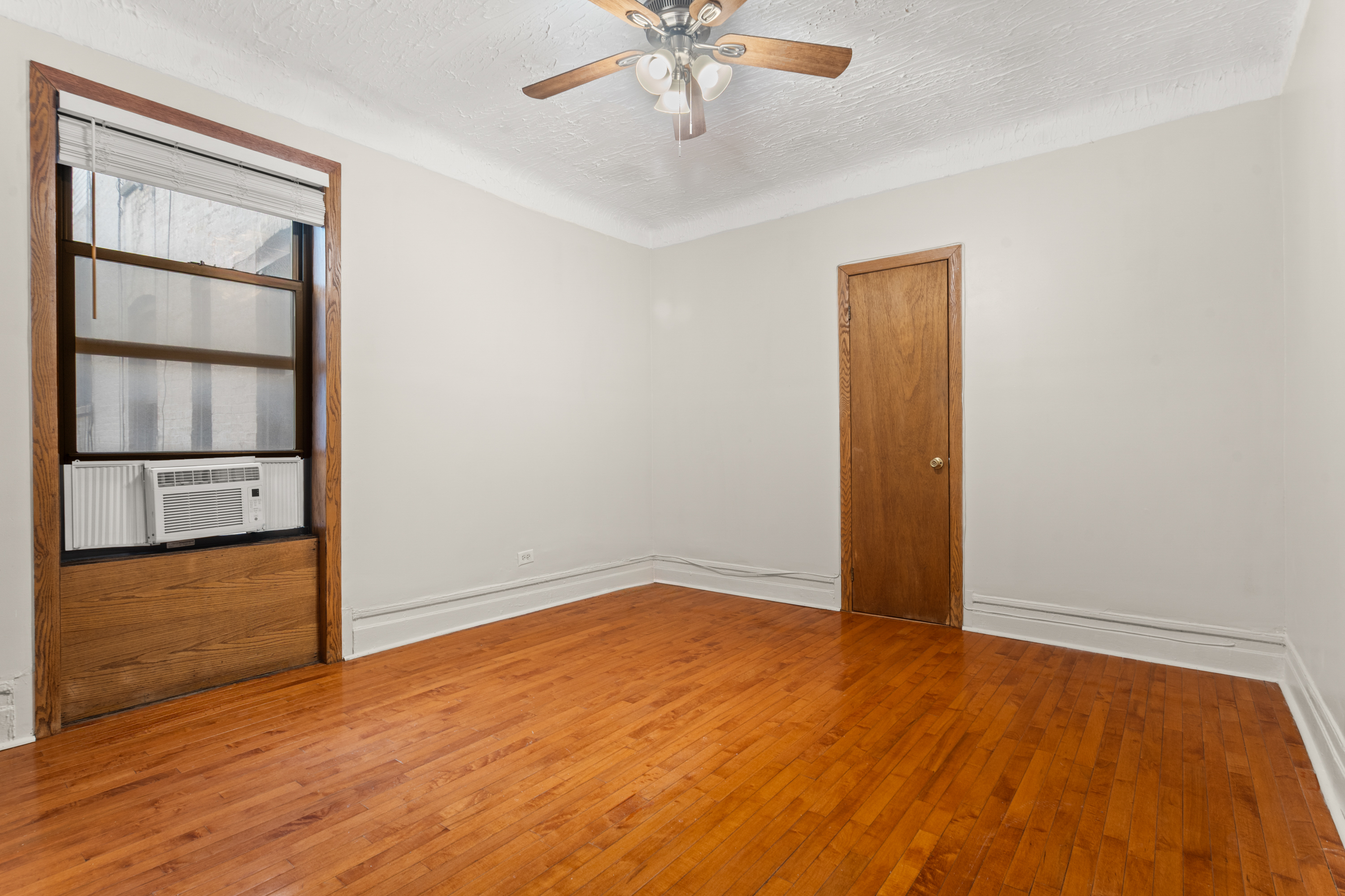 527 West 143rd Street, Unit 31 Manhattan, NY 10031 - Photo 14 of 29 an empty room with wooden floor closet and windows