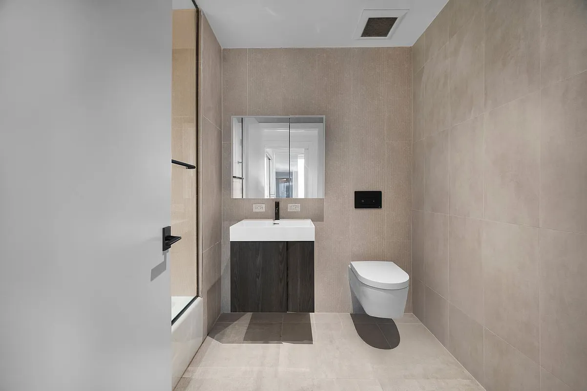 169 Huron Street, Unit 4A Brooklyn, NY 11222 - Photo 8 of 15 a bathroom with a toilet sink and mirror