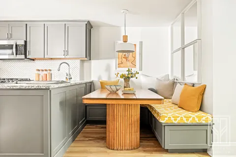 a room with kitchen island granite countertop a sink and a stove