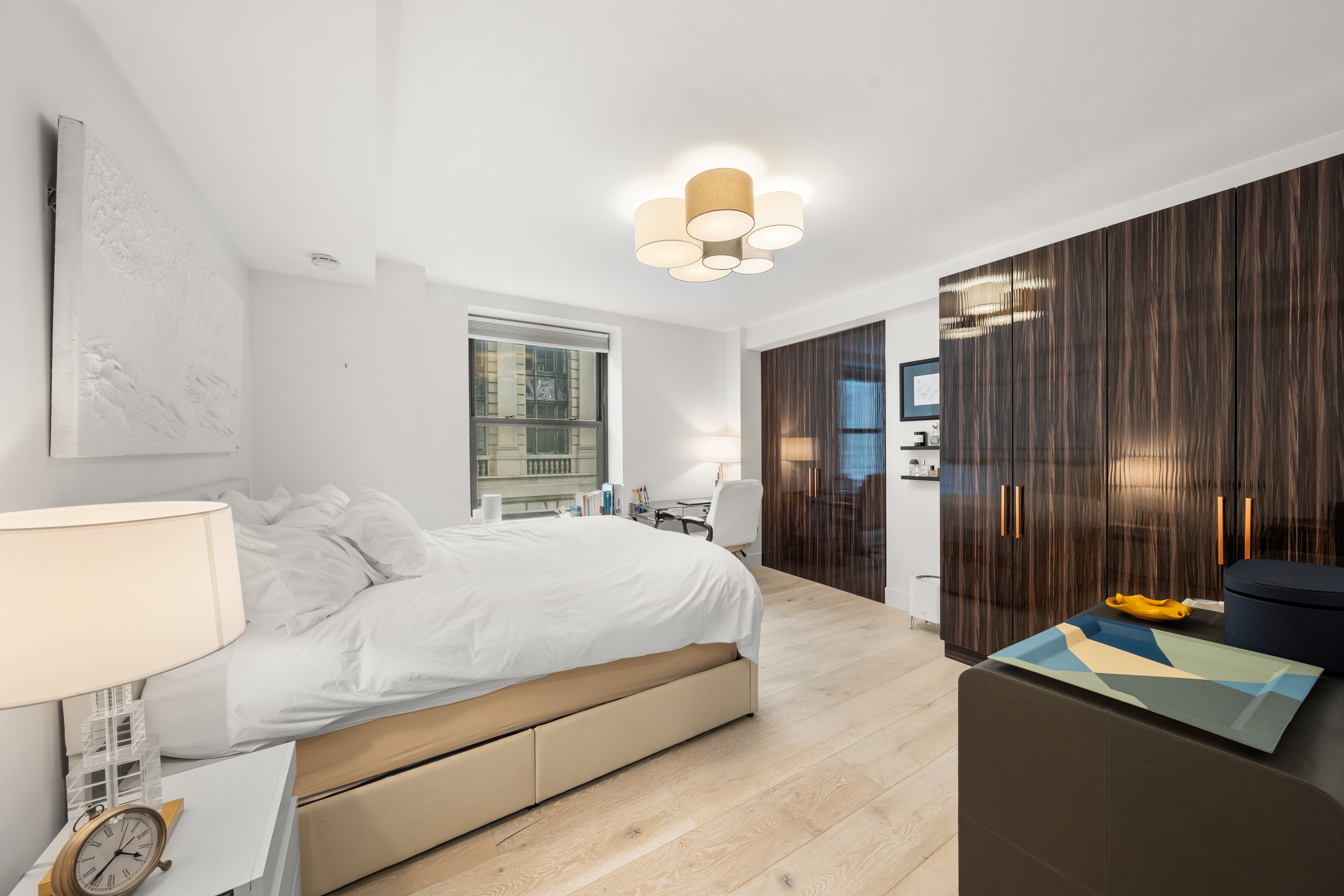 201 West 74th Street, Unit 8G Manhattan, NY 10023 - Photo 6 of 14 a bedroom with a bed and a chandelier