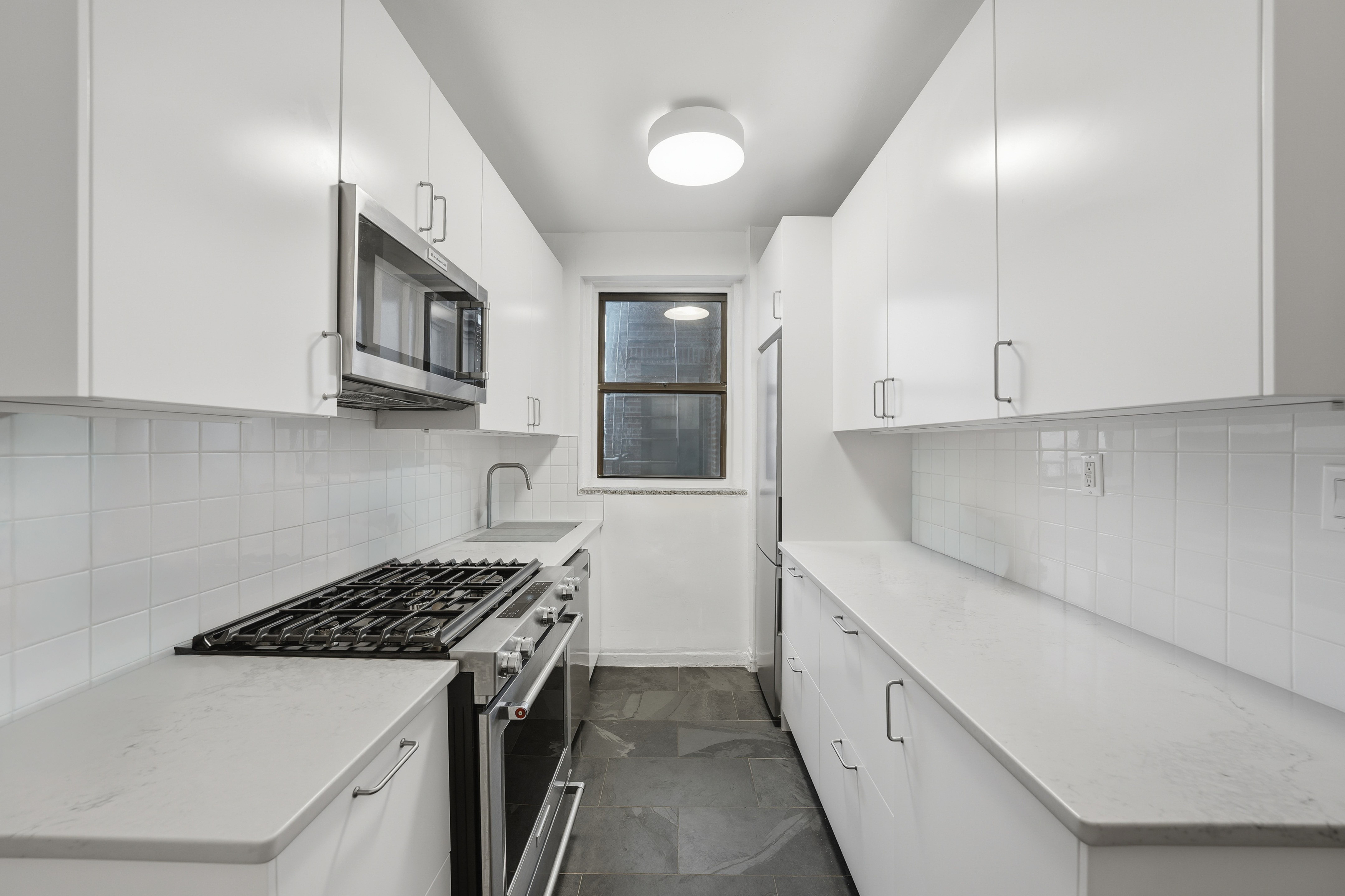 80 Avenue P, Unit D14 Brooklyn, NY 11204 - Photo 9 of 19 a kitchen with white cabinets and white appliances