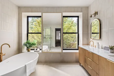 a bathroom with windows a bathtub and a sink