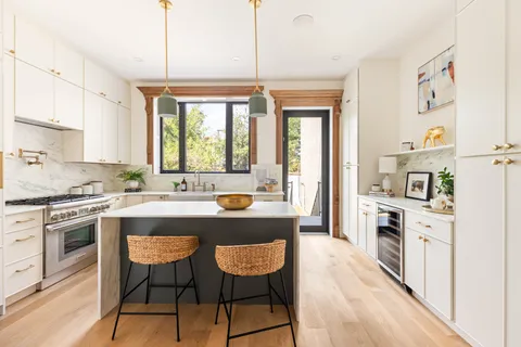 a kitchen with stainless steel appliances granite countertop a stove a sink dishwasher a oven with white cabinets and wooden floor