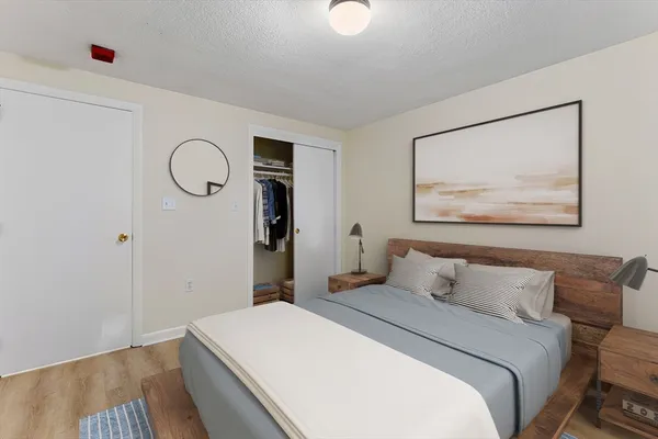 a bedroom with a bed and a painting on the wall