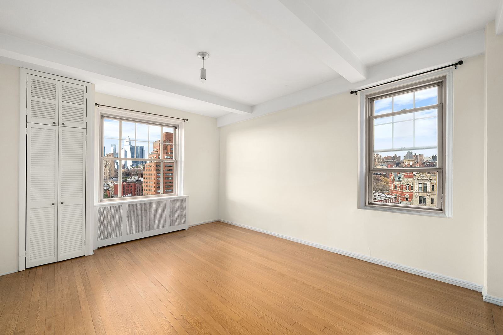 45 Christopher Street, Unit 12/14F Manhattan, NY 10014 - Photo 12 of 18 an empty room with wooden floor and windows