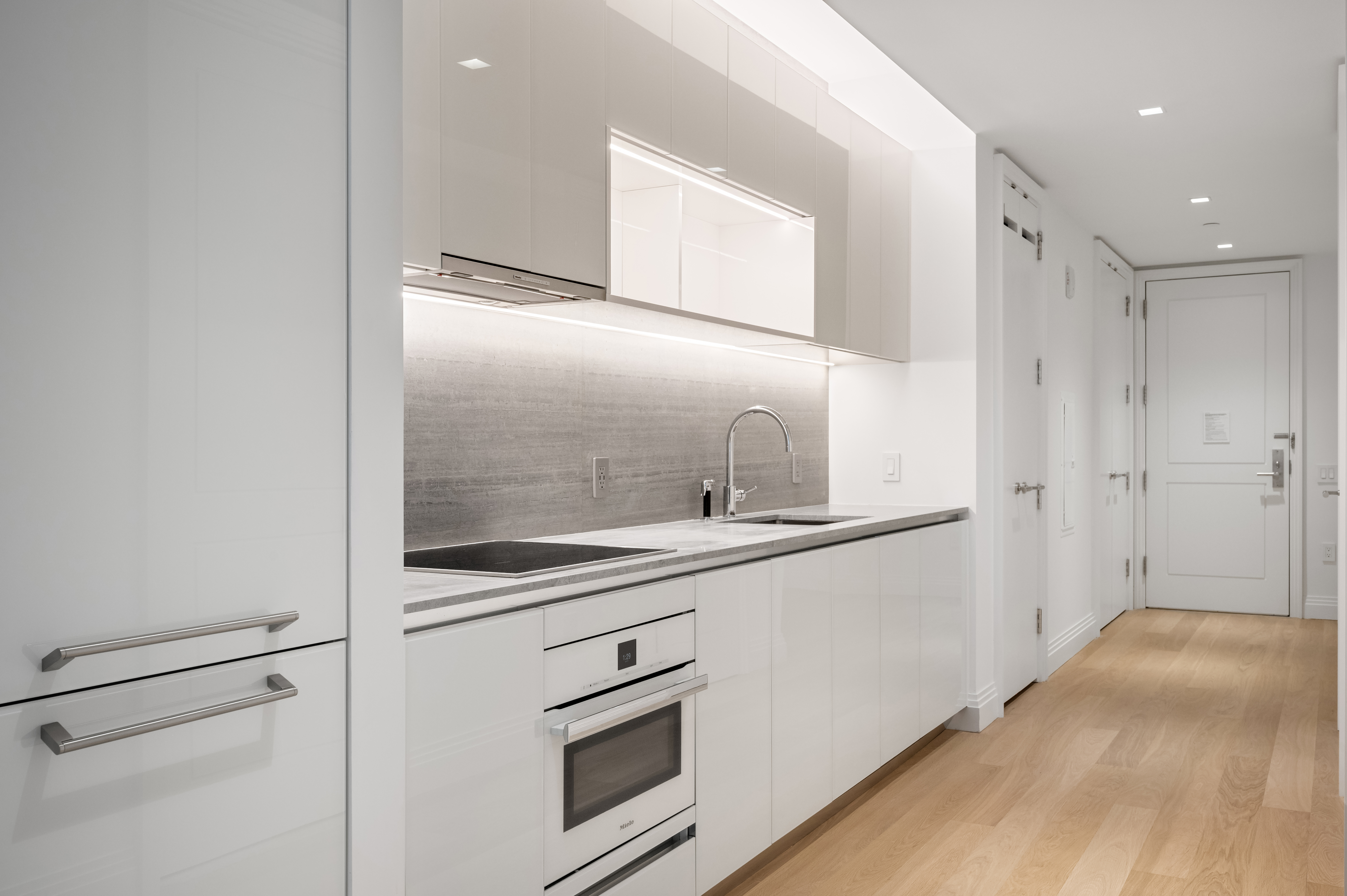 1 Wall Street, Unit 915 Manhattan, NY 10005 - Photo 2 of 18 a kitchen with stainless steel appliances granite countertop a sink and a refrigerator