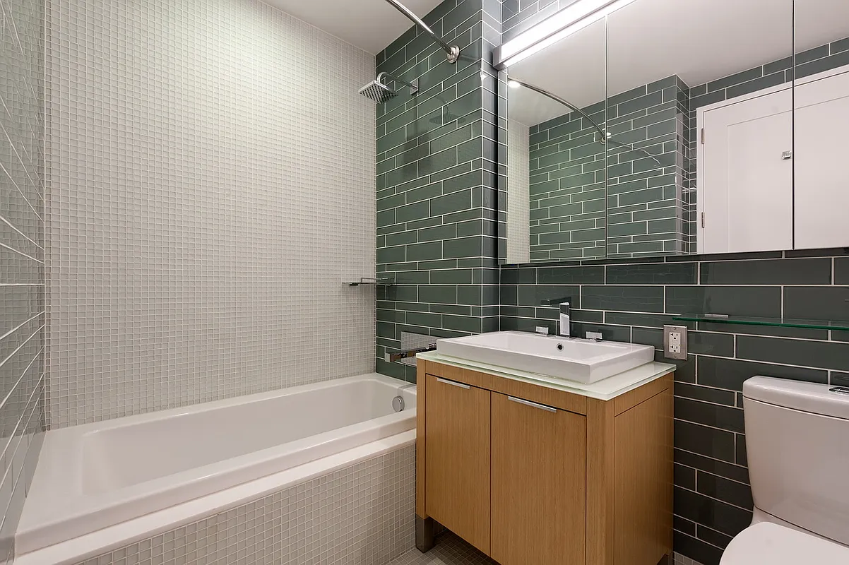22 North 6th Street, Unit 23E Brooklyn, NY 11249 - Photo 5 of 10 a bathroom with a sink toilet vanity and tub