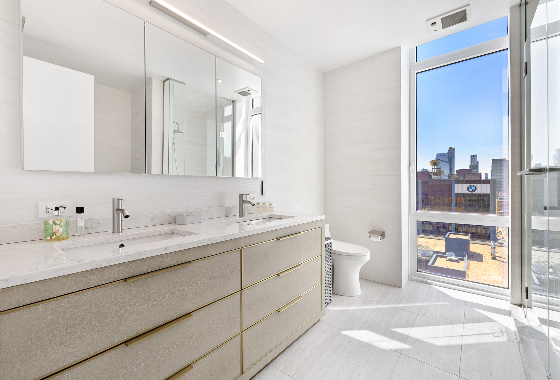 10 West End Avenue, Unit 30C Manhattan, NY 10023 - Photo 13 of 22 a bathroom with a double vanity sink toilet and a mirror