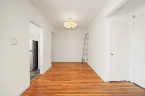 a view of a room with wooden floor and a window