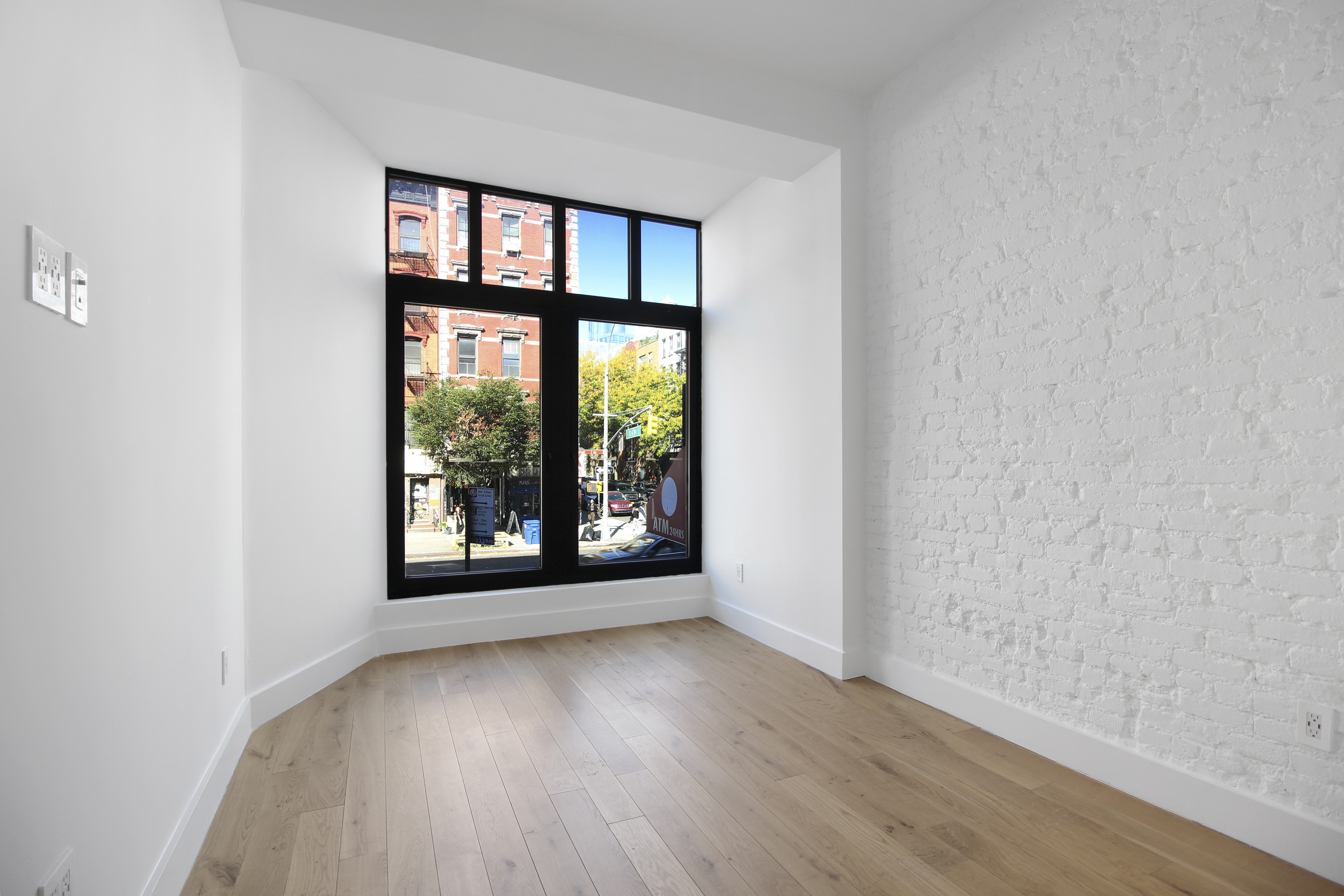 100 2nd Avenue, Unit 2 Manhattan, NY 10003 - Photo 6 of 10 an empty room with wooden floor and windows