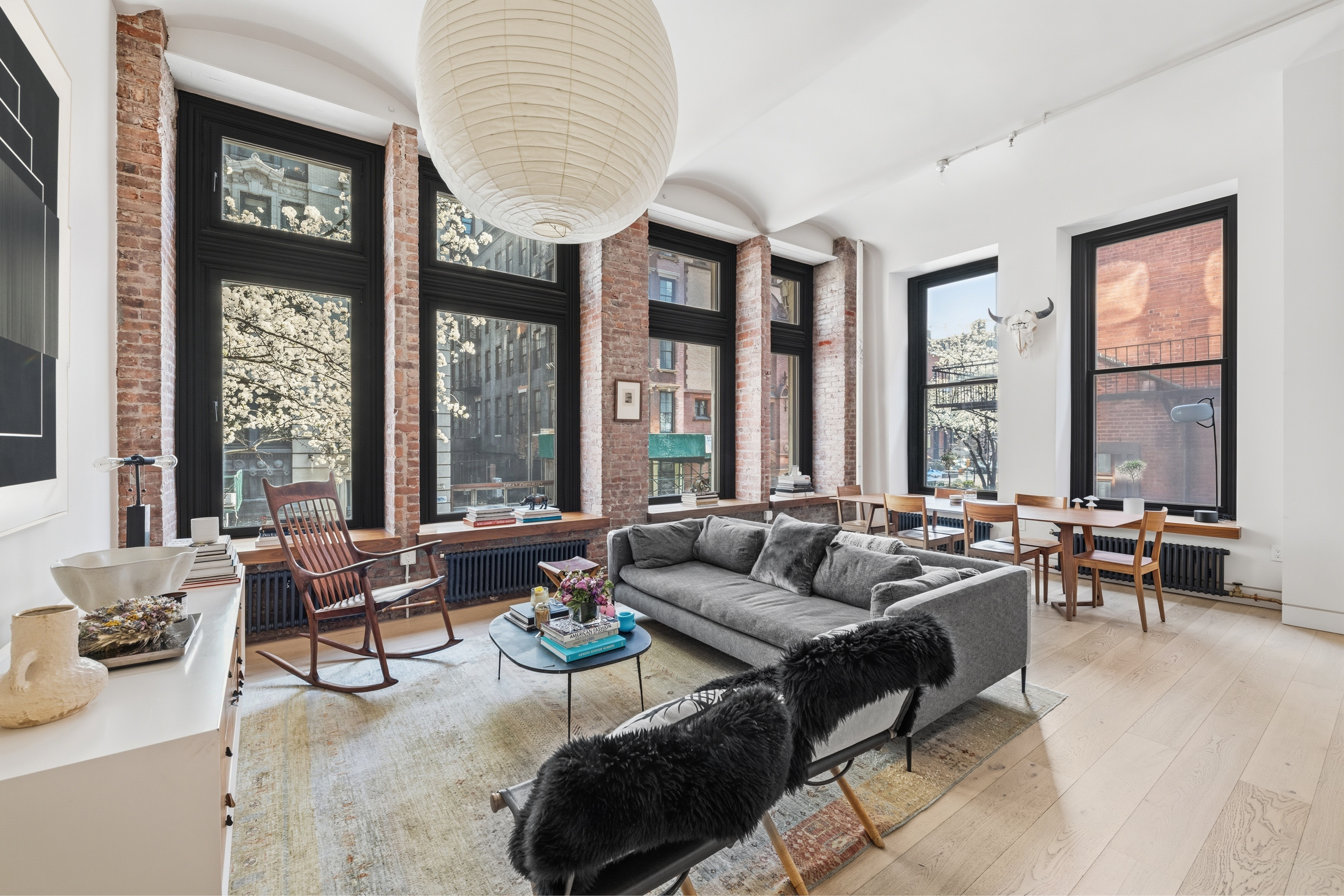1 Great Jones St, Unit 2B Manhattan, NY 10012 - Photo 1 of 12 a living room with furniture and floor to ceiling windows