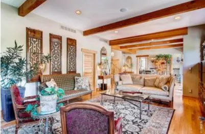 a living room with furniture large window and wooden floor