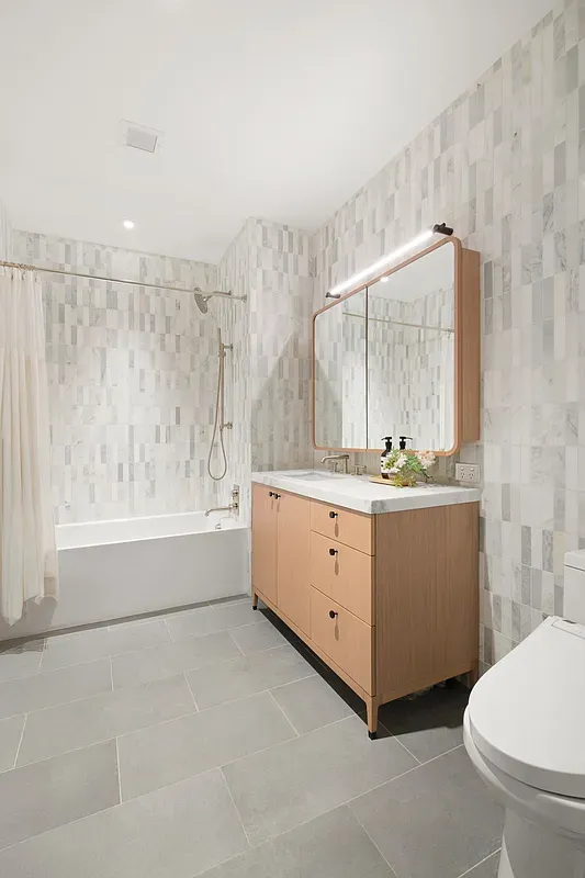 a bathroom with a granite countertop sink a toilet and mirror