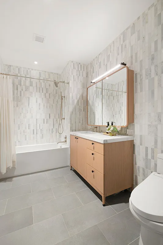 180 Front Street, Unit 9A Brooklyn, NY 11201 - Photo 9 of 25 a bathroom with a granite countertop sink a toilet and mirror