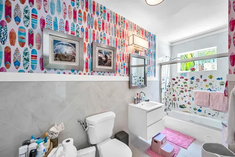 a bathroom with a sink mirror vanity and toilet