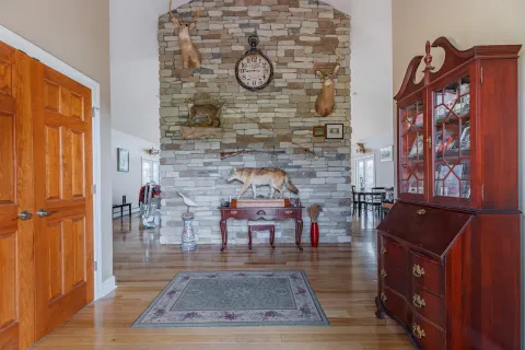 a living room with furniture large window and wooden floor