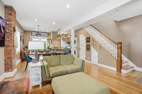 a living room with furniture a flat screen tv and windows