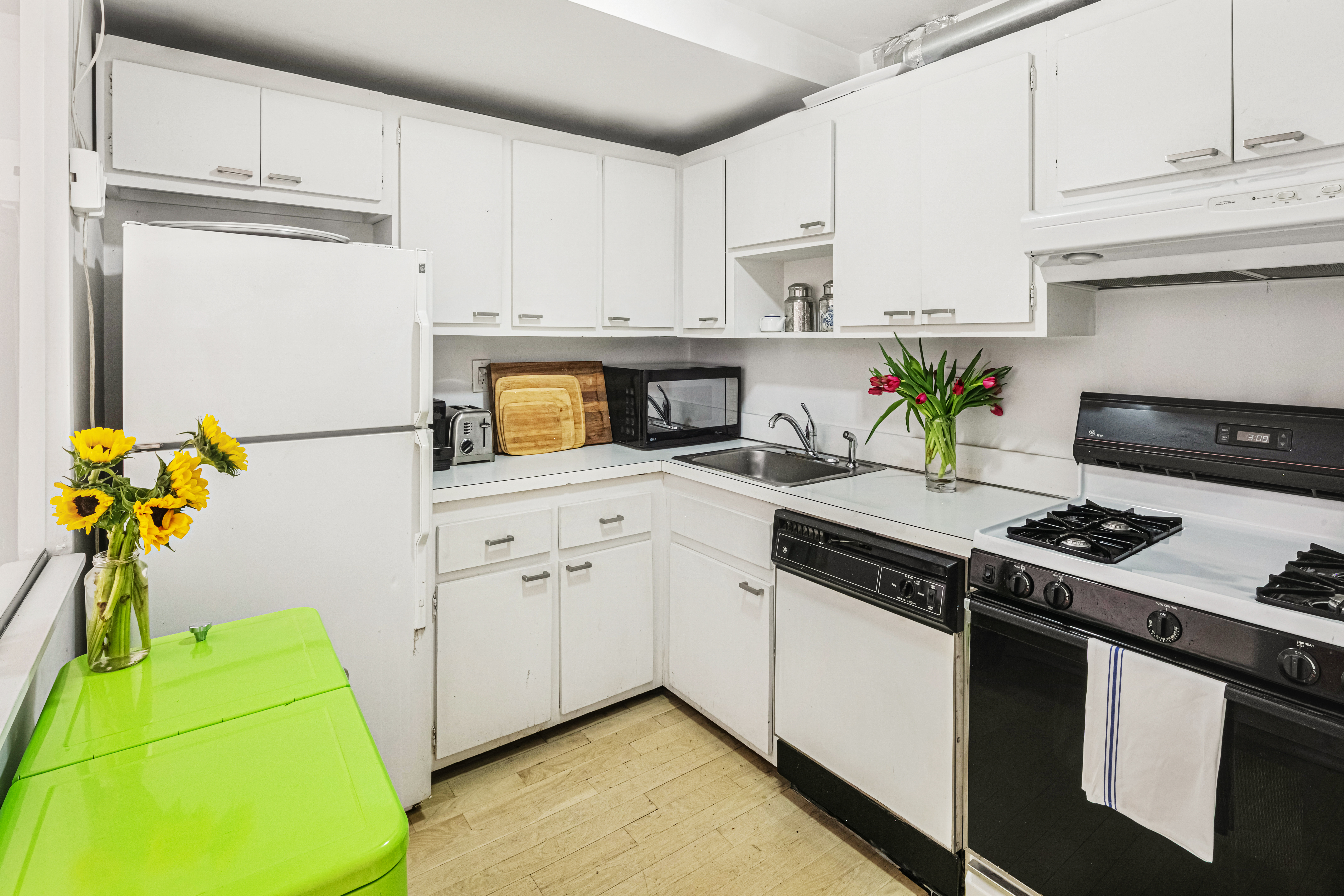 251 West 19th Street, Unit 1G Manhattan, NY 10011 - Photo 11 of 31 a kitchen with a stove and a white cabinets