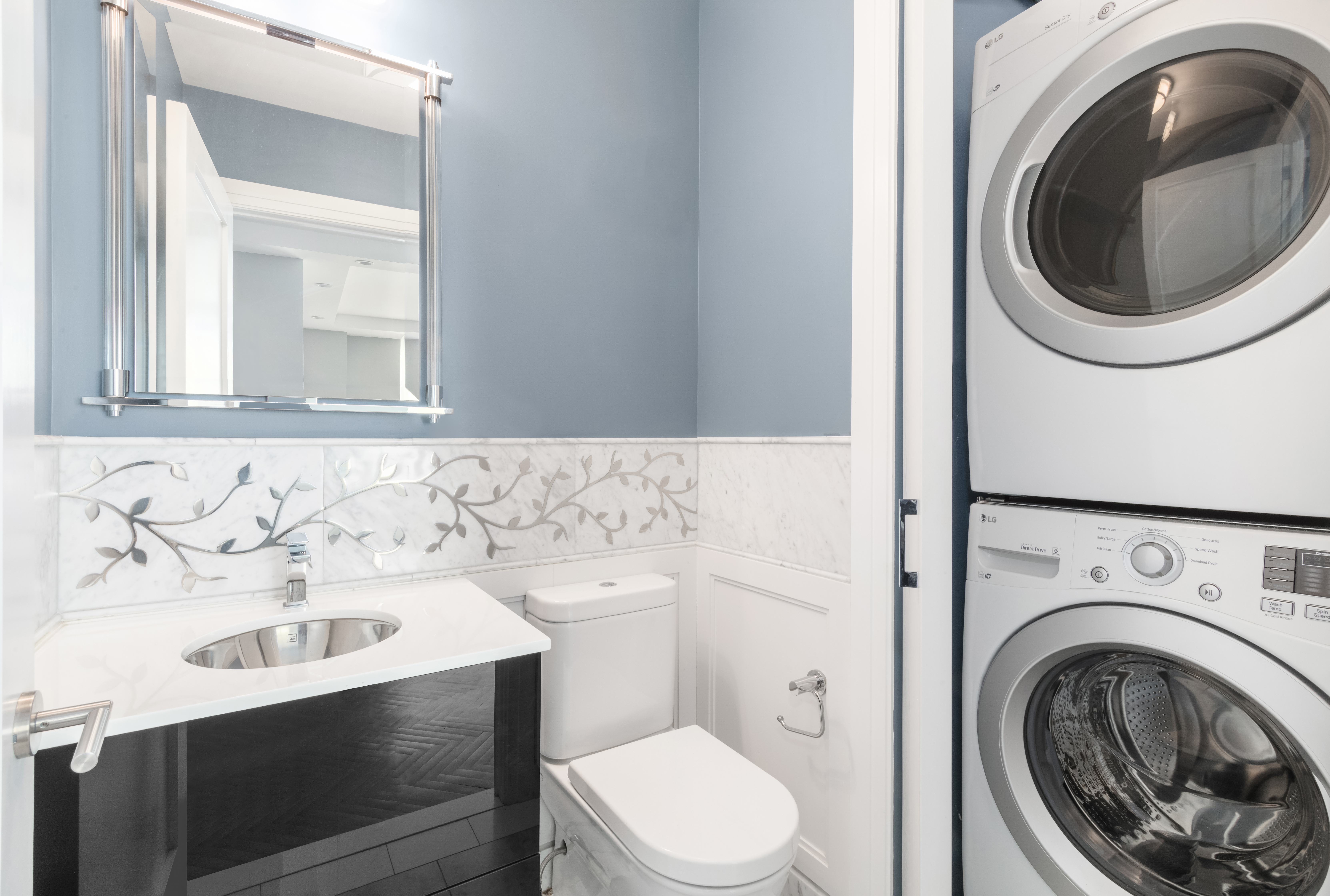 360 East 88th Street, Unit 20D Manhattan, NY 10128 - Photo 9 of 15 a bathroom with a sink a washer and dryer
