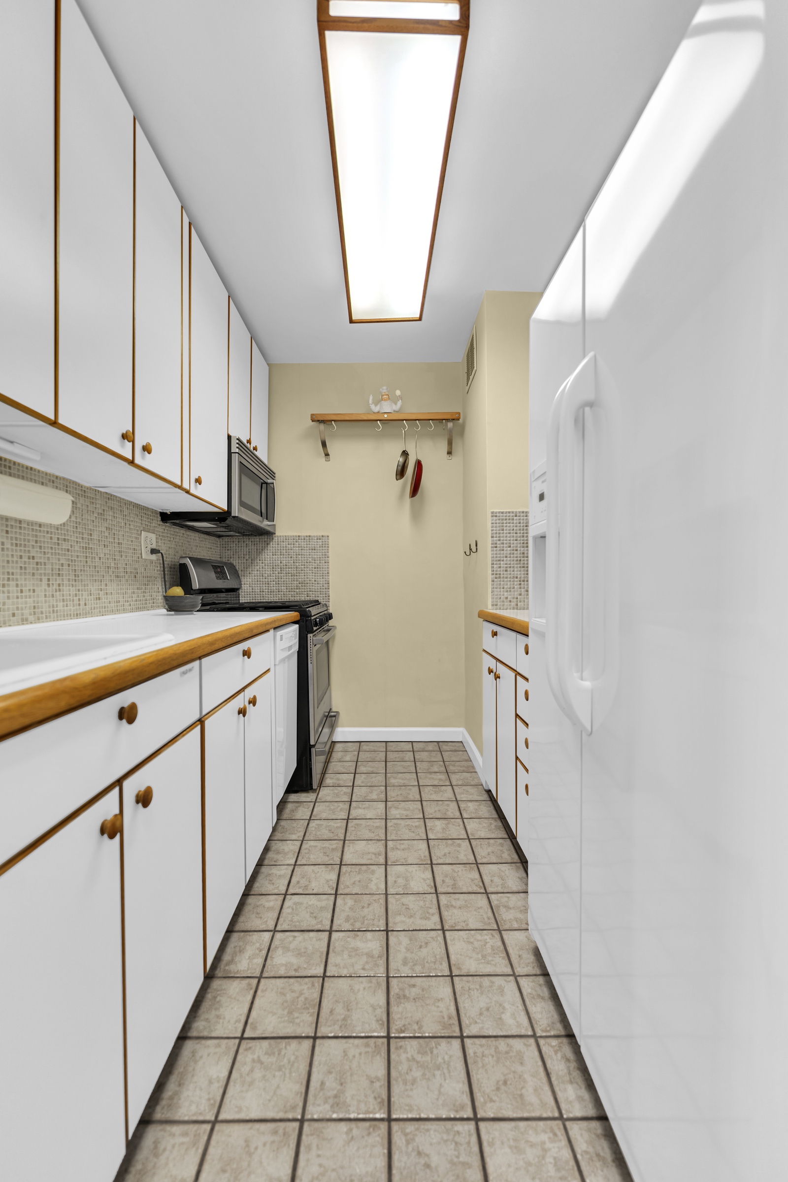 205 West End Avenue, Unit 23E Manhattan, NY 10023 - Photo 11 of 15 a kitchen with granite countertop white cabinets and white appliances