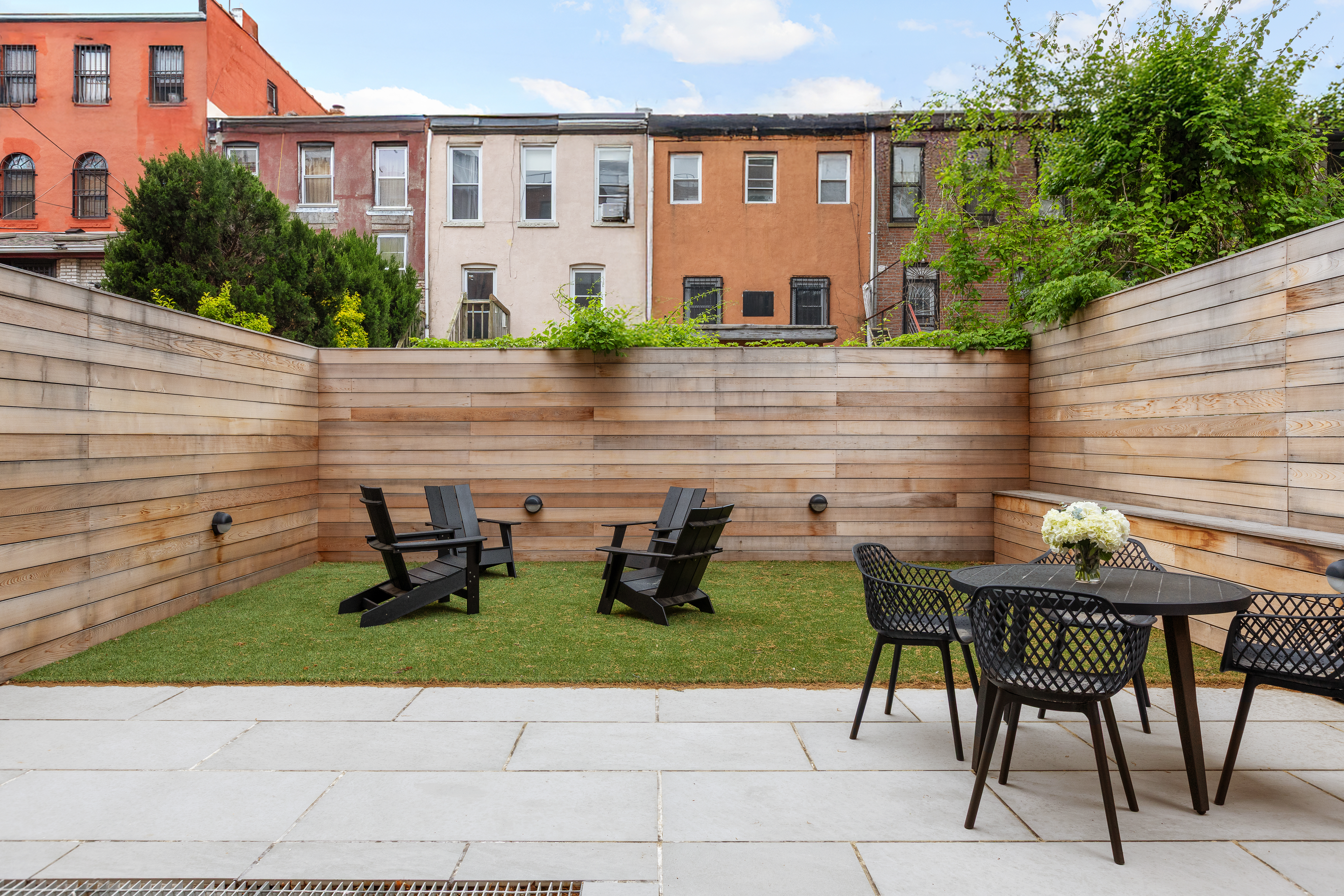 524 Halsey Street, Unit 105 Brooklyn, NY 11233 - Photo 9 of 15 a backyard of a house with barbeque oven table and chairs
