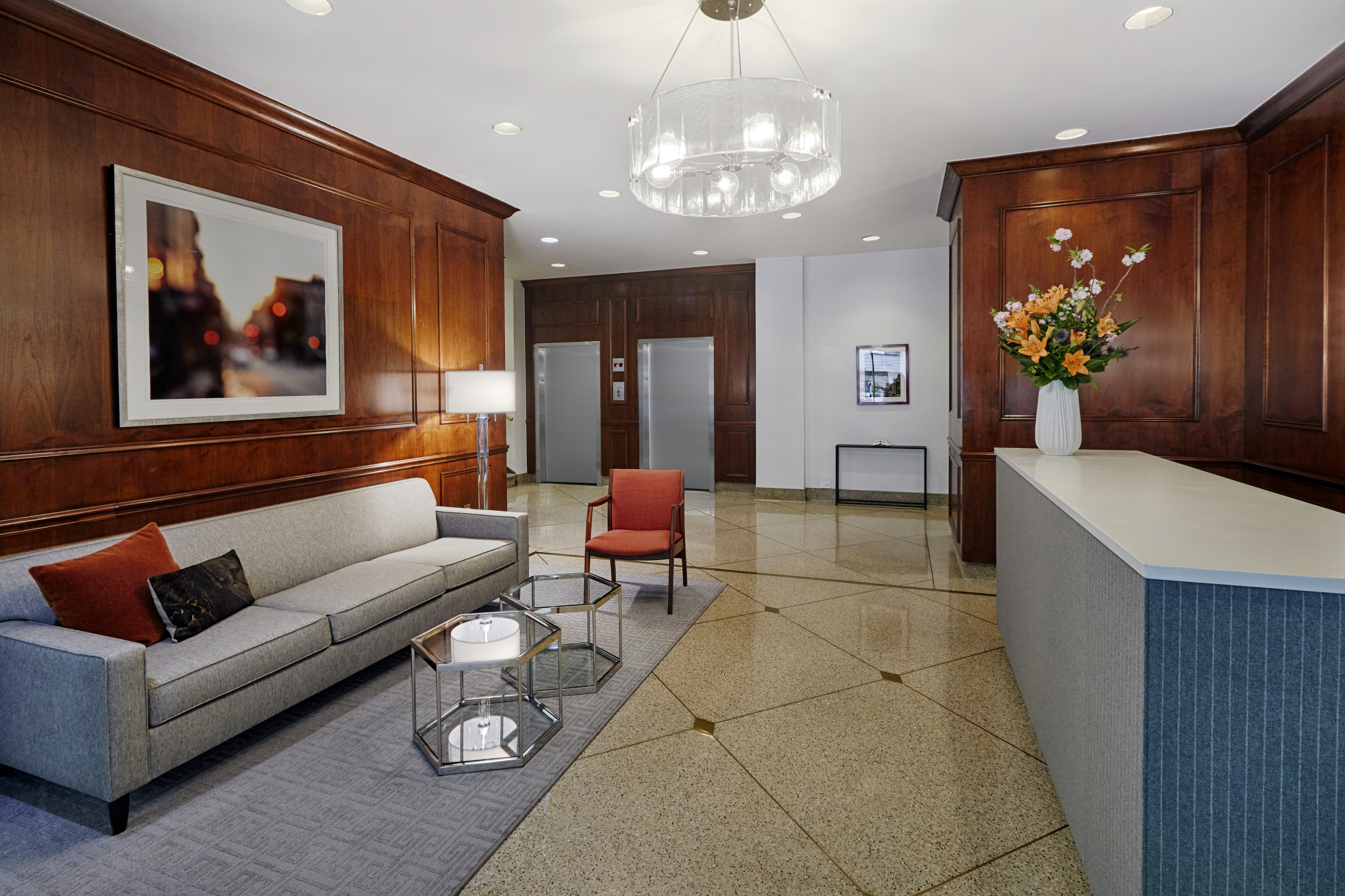 225 East 46th Street, Unit 12G Manhattan, NY 10017 - Photo 14 of 19 a living room with furniture a chandelier and a painting on the wall