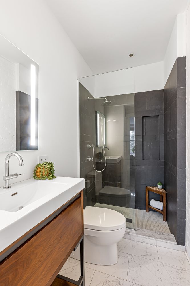 a bathroom with a sink a toilet and shower