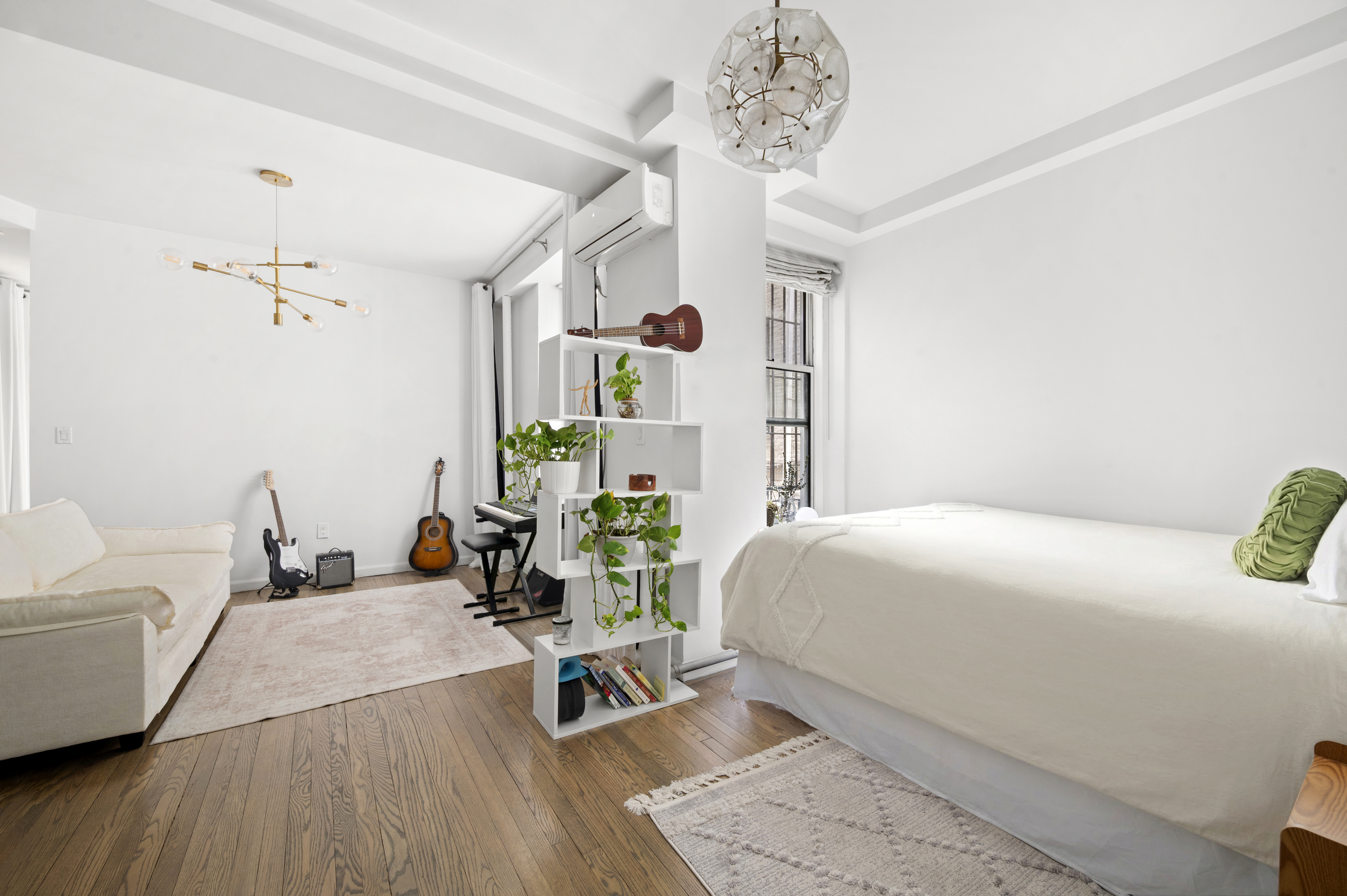 251 West 98th Street, Unit DD Manhattan, NY 10025 - Photo 2 of 6 a bedroom with a bed a chandelier and mirror