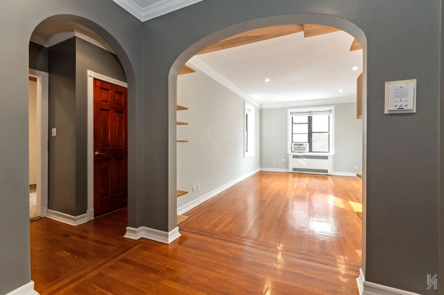 a view of empty room with wooden floor and fan