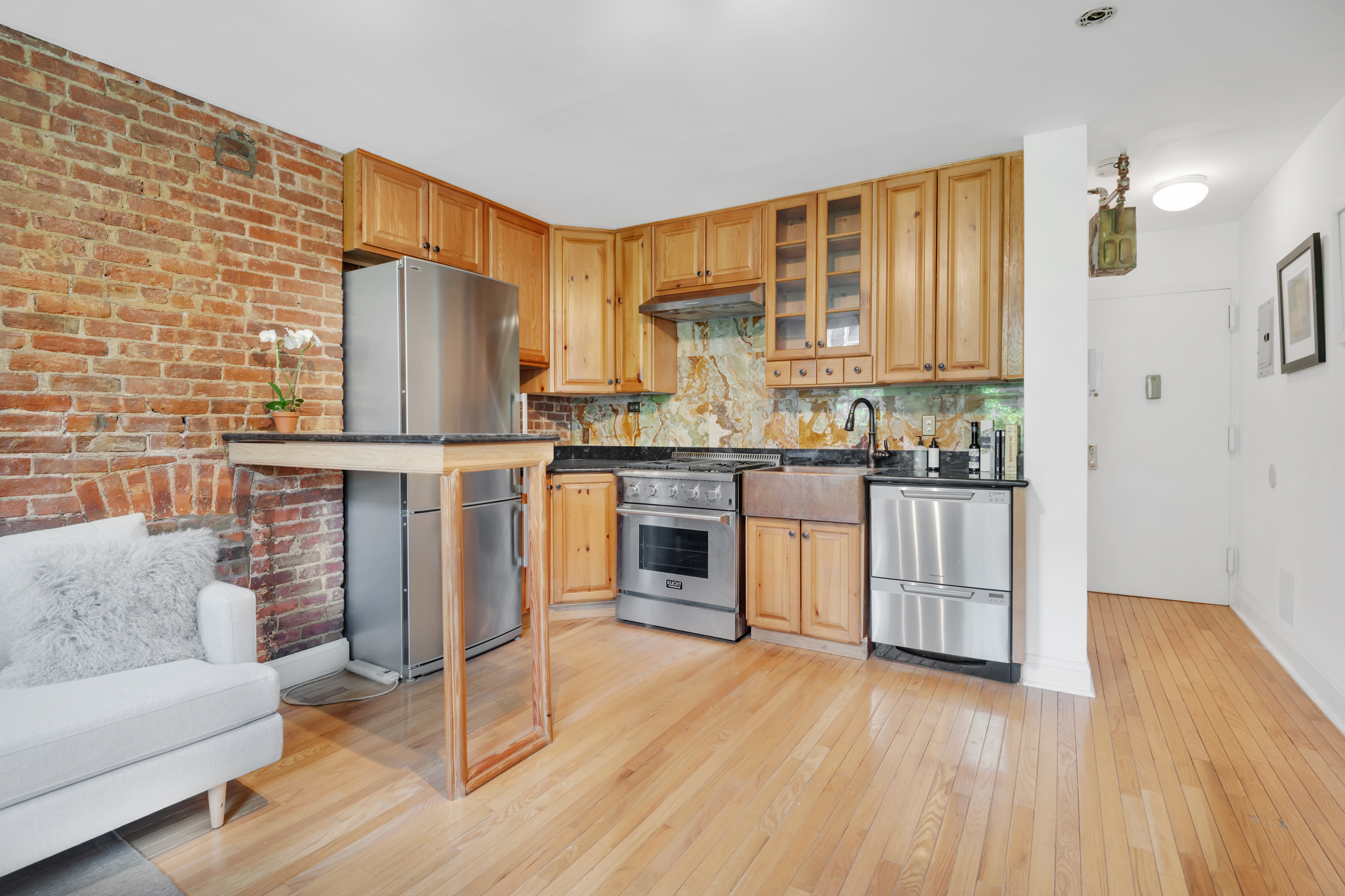 220 East 82nd Street, Unit 4RW Manhattan, NY 10028 - Photo 5 of 11 a kitchen with stainless steel appliances a stove top oven and a refrigerator