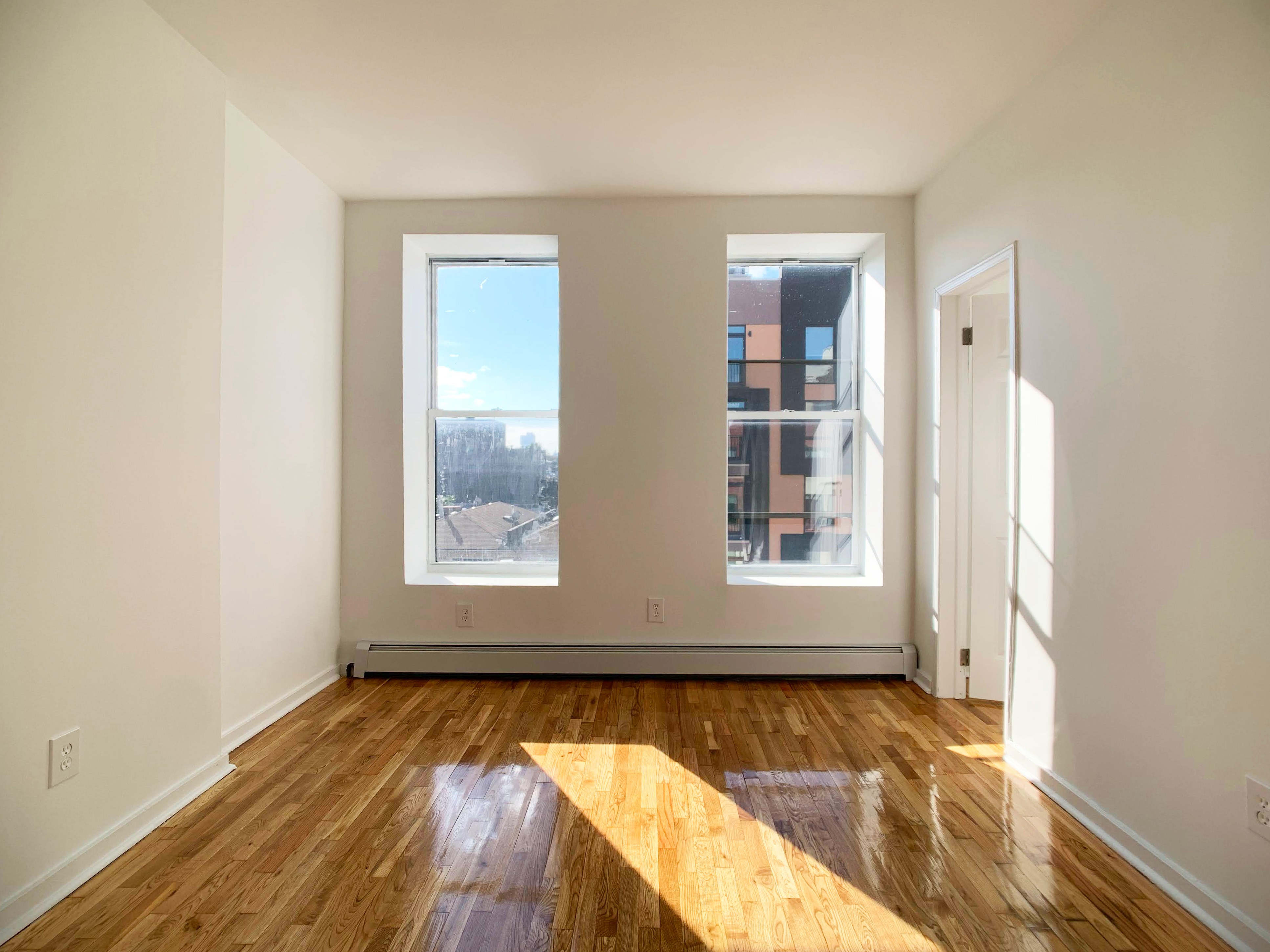 293 Tompkins Avenue Brooklyn, NY 11221 - Photo 2 of 19 an empty room with wooden floor and windows