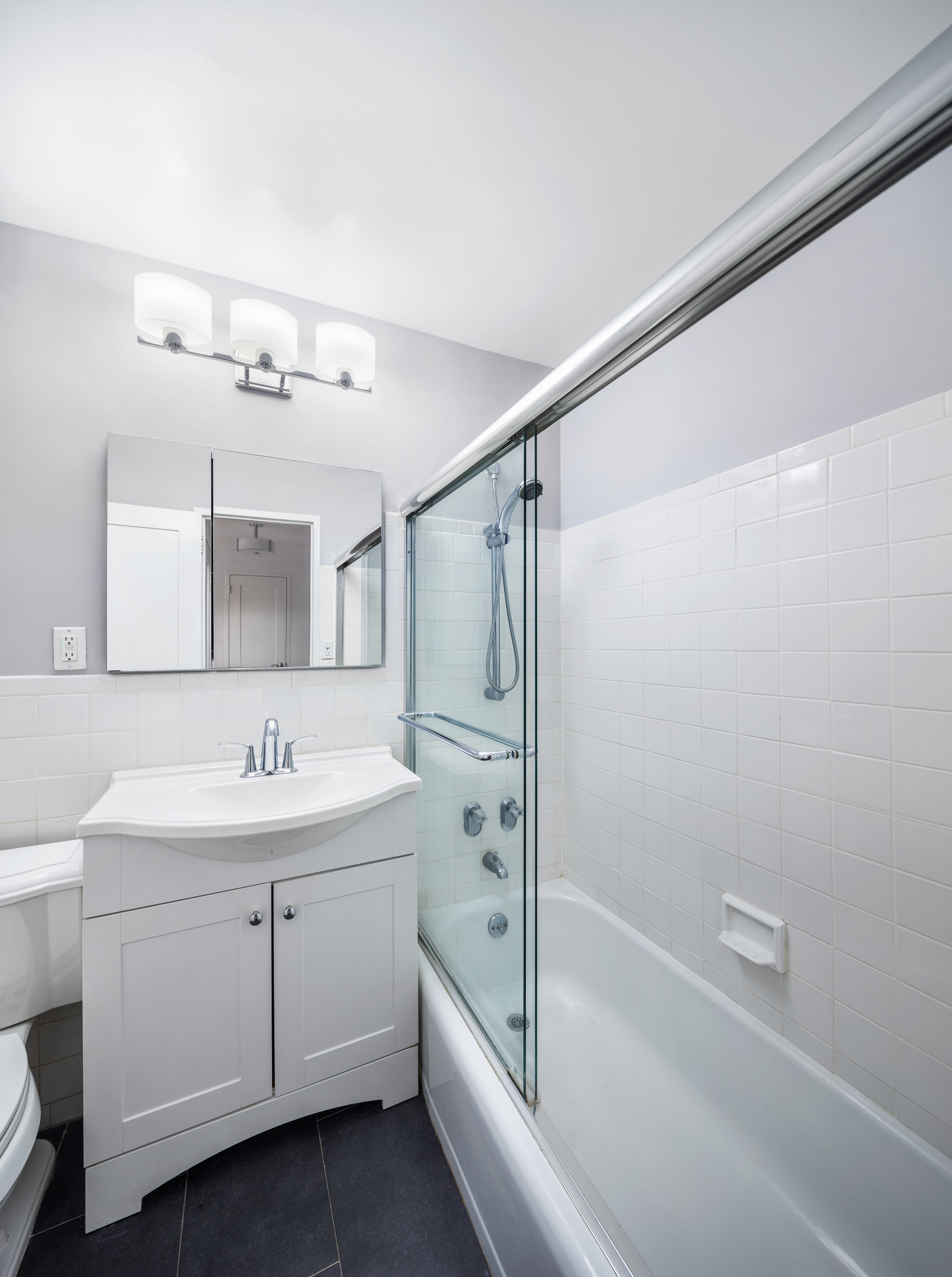 333 East 79th Street, Unit 4R Manhattan, NY 10075 - Photo 6 of 7 a bathroom with a tub sink a mirror and a shower