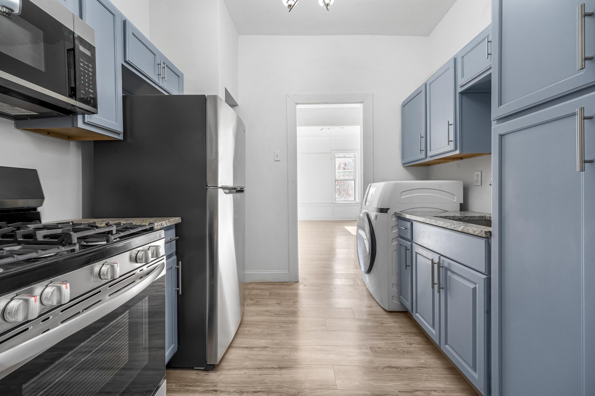 1384 Pacific Street, Unit A2 Brooklyn, NY 11216 - Photo 5 of 16 a kitchen with stainless steel appliances granite countertop a stove and a refrigerator