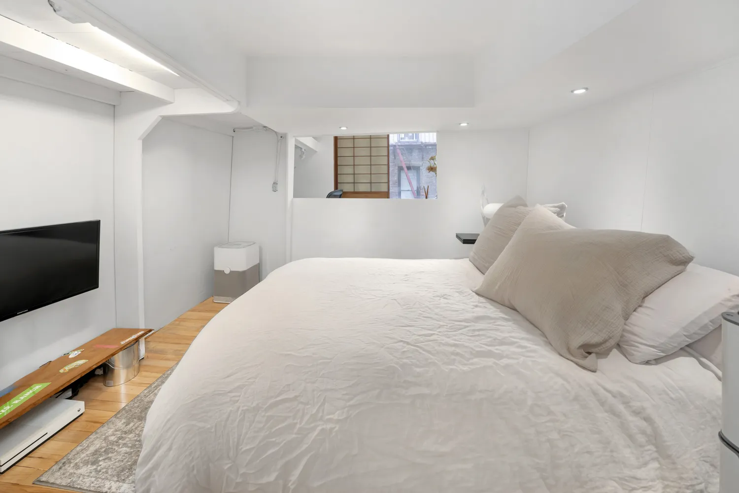 a bedroom with a bed and a flat tv screen on wall