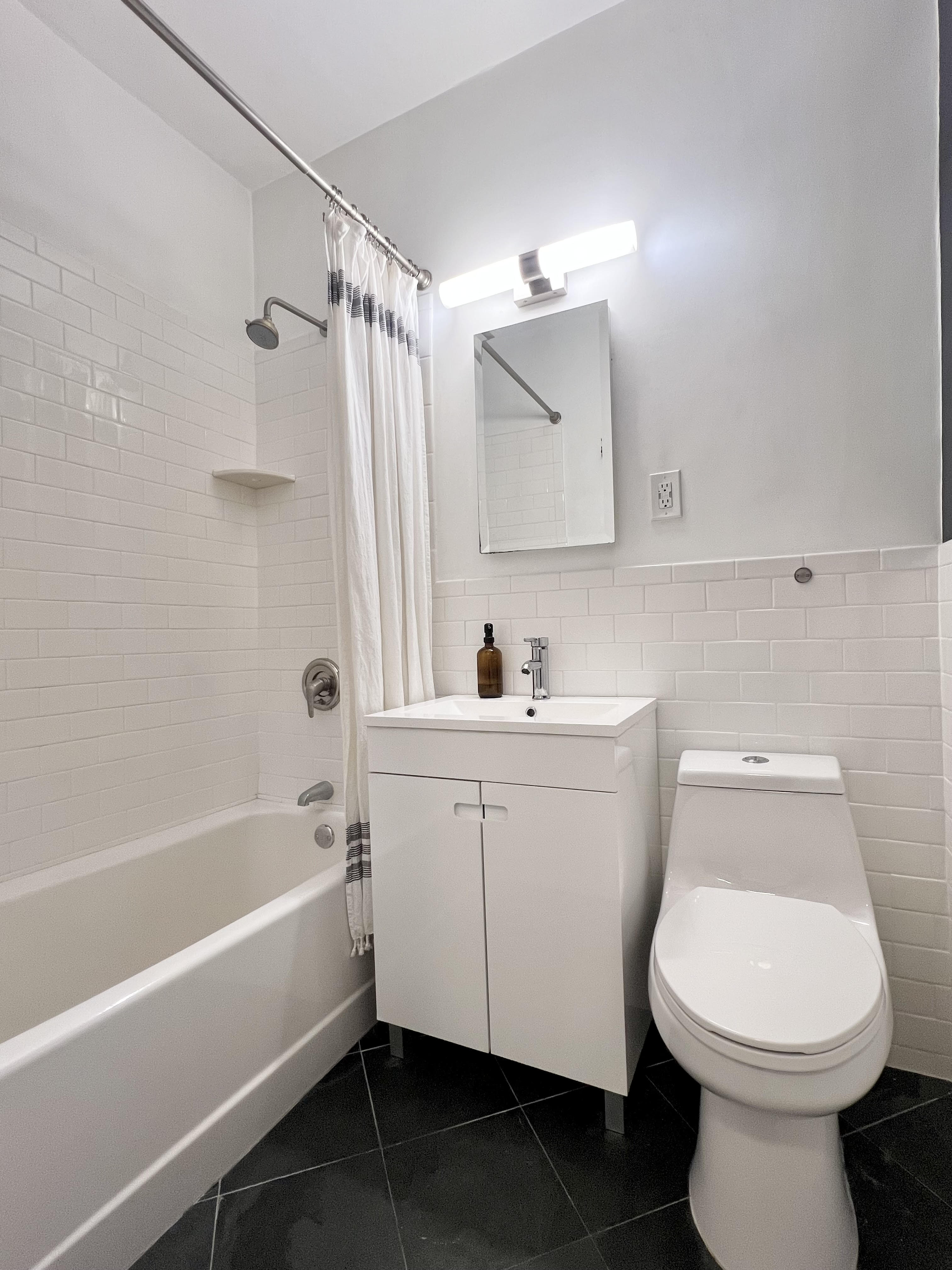 104 East 37th Street, Unit 5C Manhattan, NY 10016 - Photo 5 of 9 a bathroom with a sink toilet vanity and bathtub