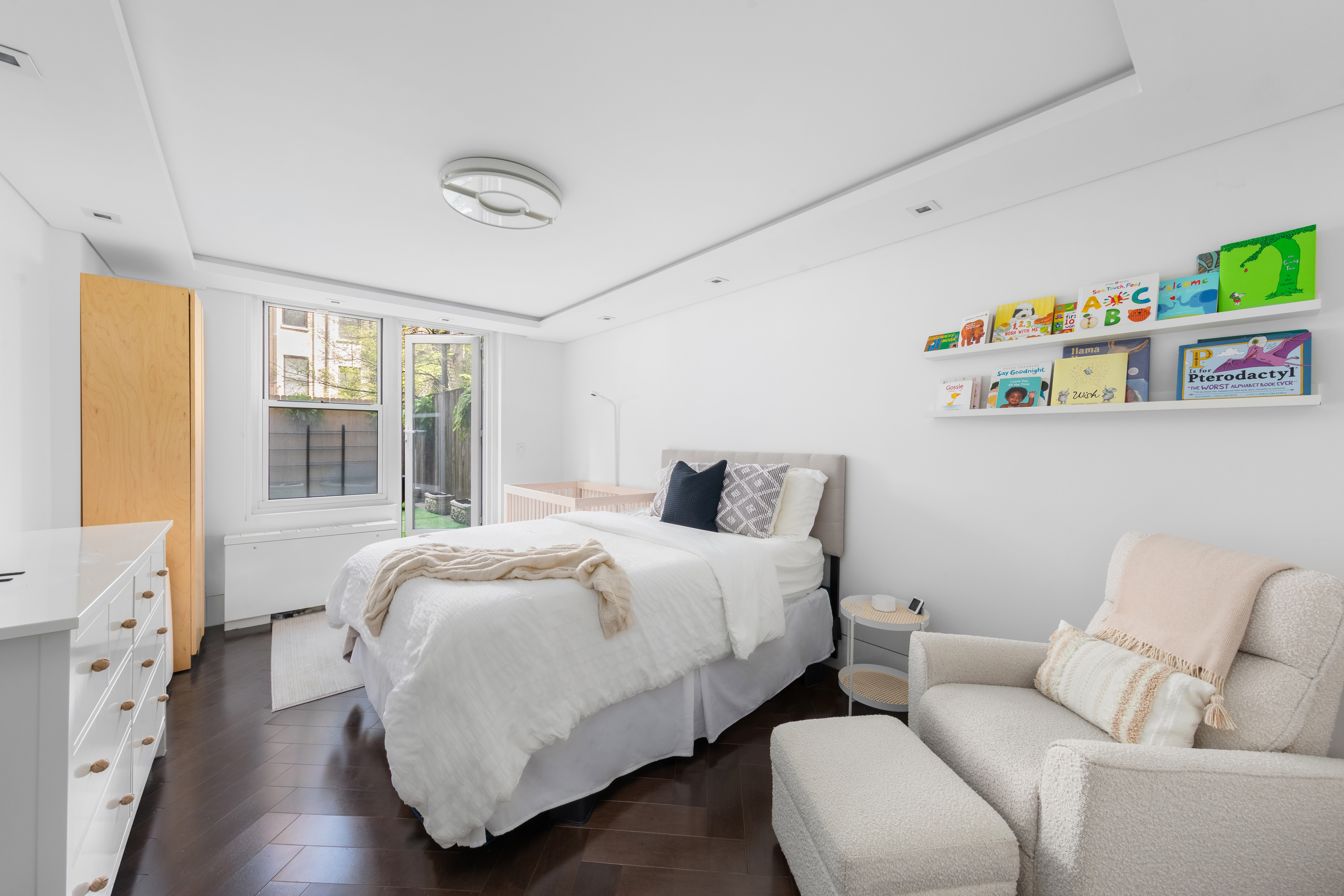 207 East 74th Street, Unit 1J Manhattan, NY 10021 - Photo 7 of 9 a bedroom with a bed and wooden floor