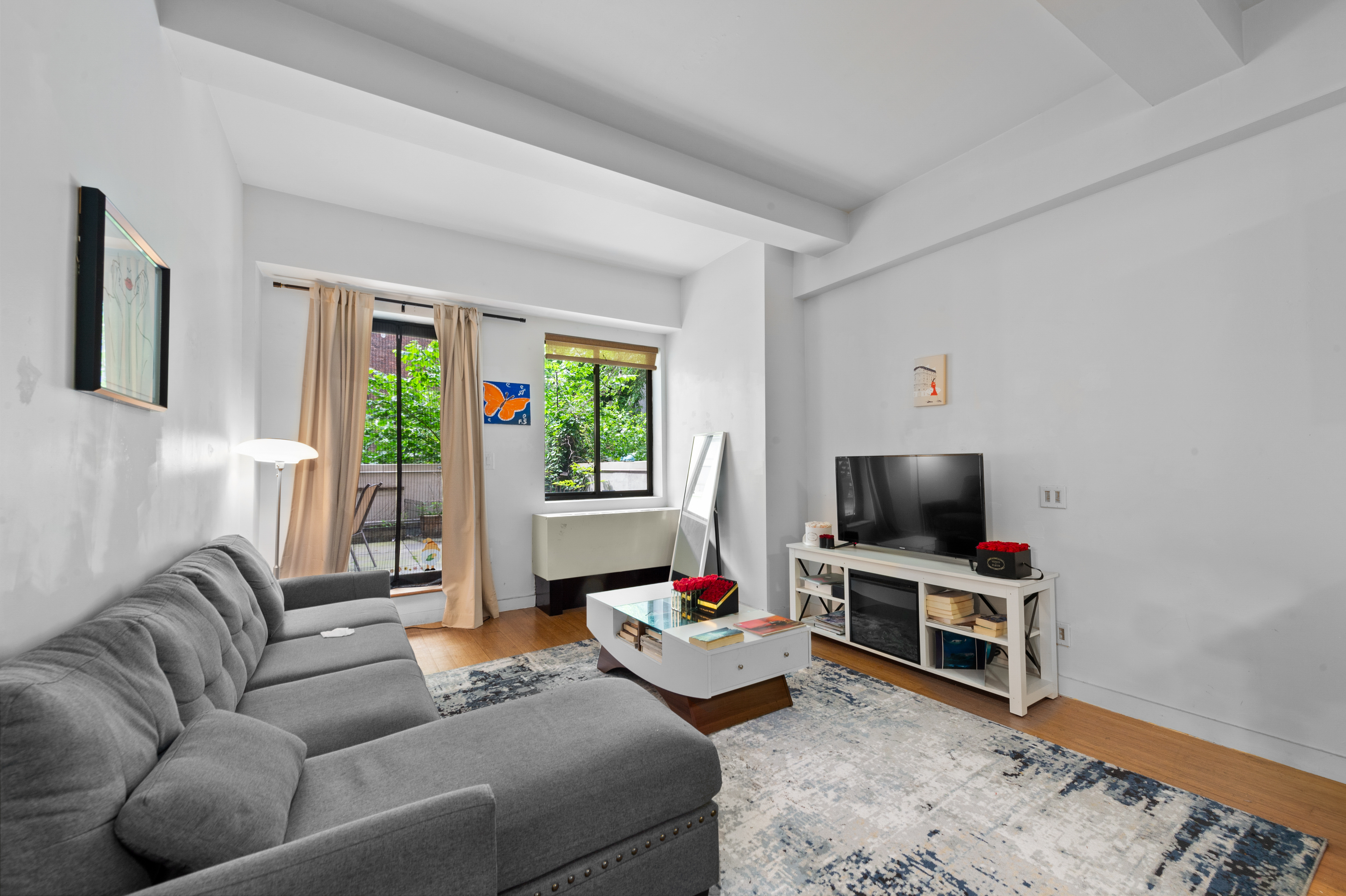 353 East 104th Street, Unit 2F Manhattan, NY 10029 - Photo 3 of 10 a living room with furniture and a flat screen tv