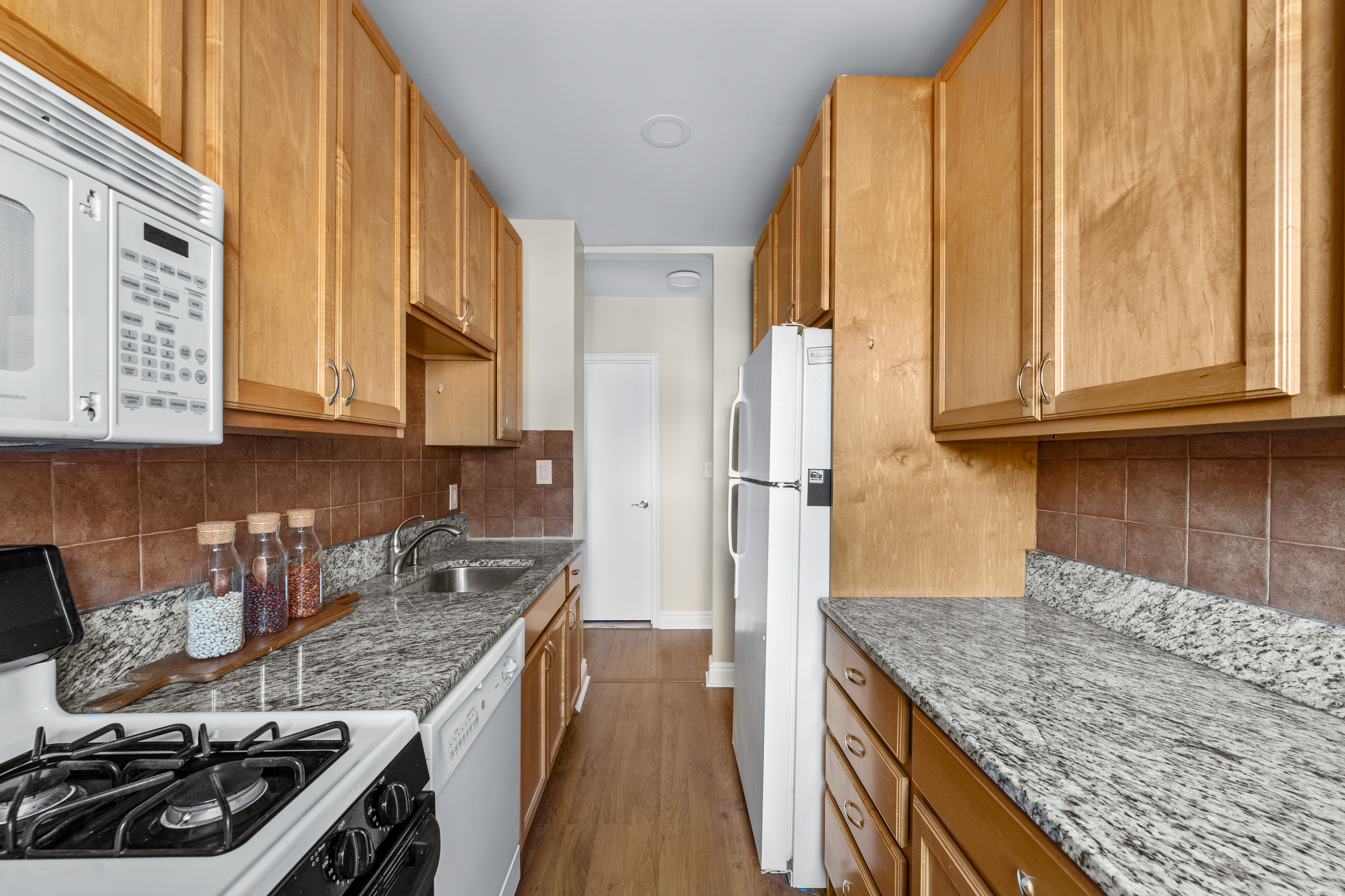 71-36 110th Street, Unit PH7E Queens, NY 11375 - Photo 9 of 16 a kitchen with stainless steel appliances granite countertop a sink stove and refrigerator
