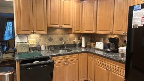 a kitchen with granite countertop a sink a stove and cabinets