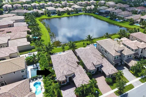 an aerial view of a house with a garden and lake view