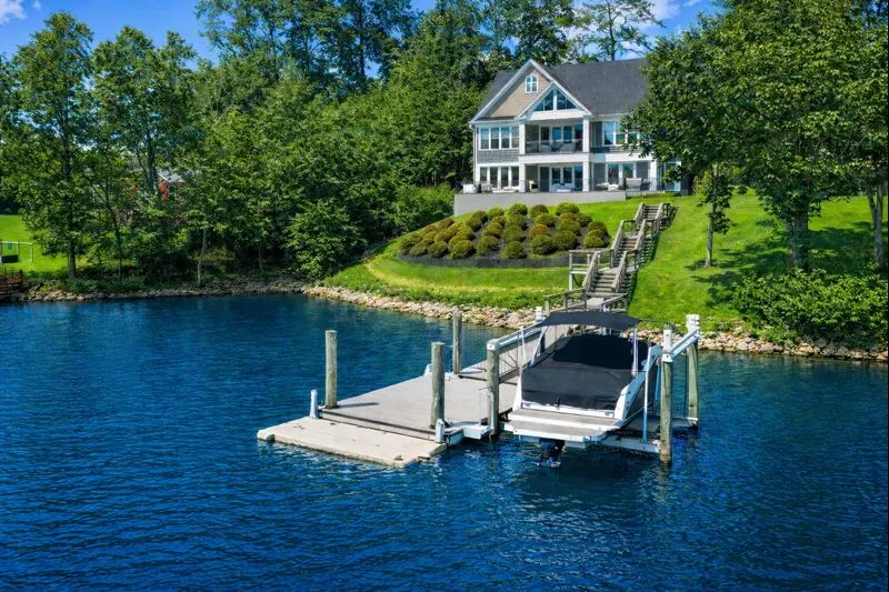a white bench sitting in the middle of a house next to a lake