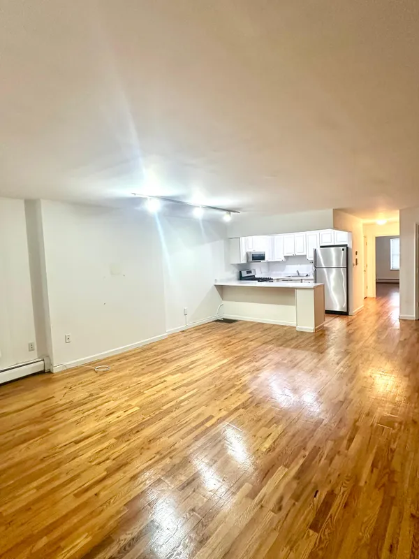 a view of empty room with wooden floor