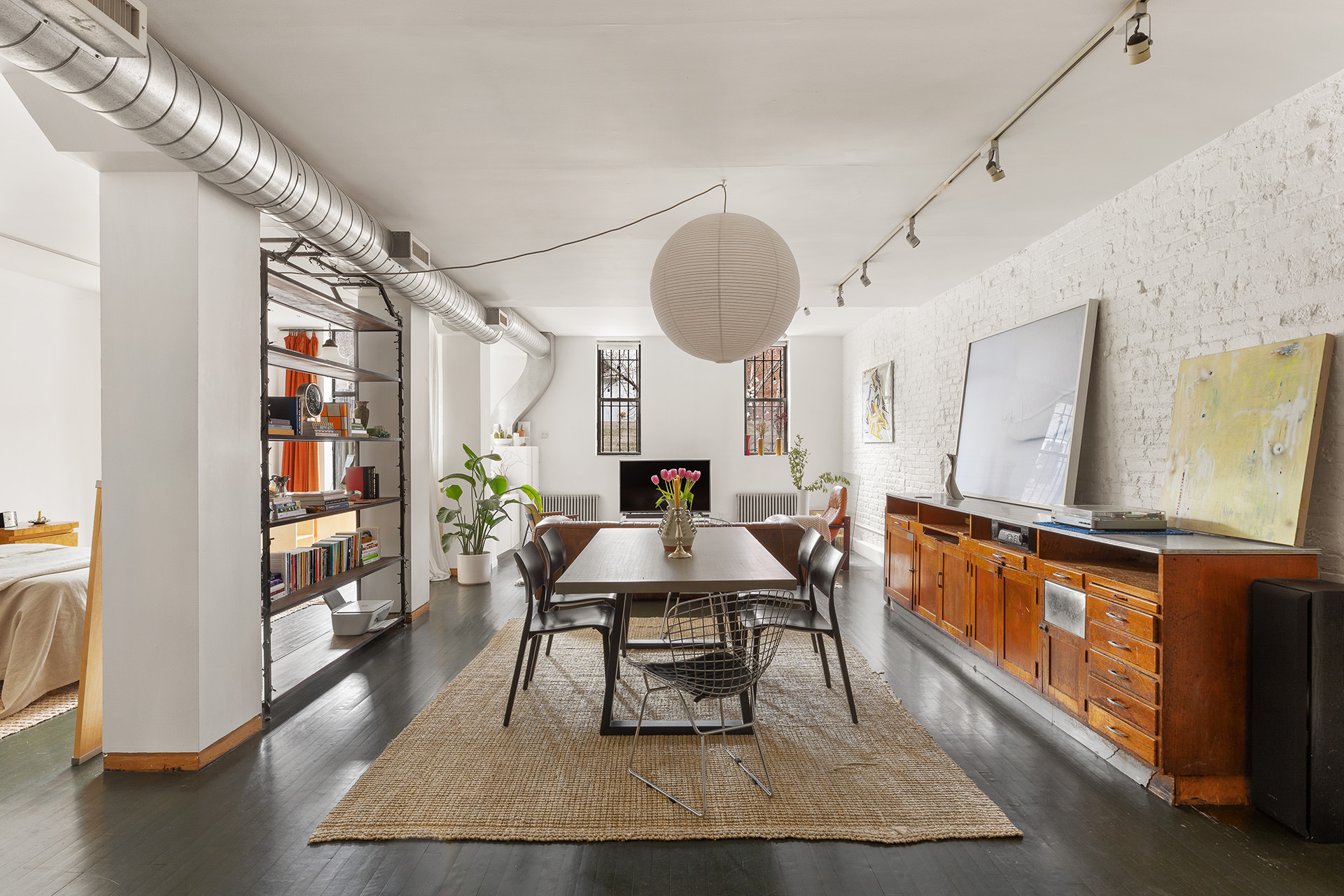 a dining room with wooden floor and large windows