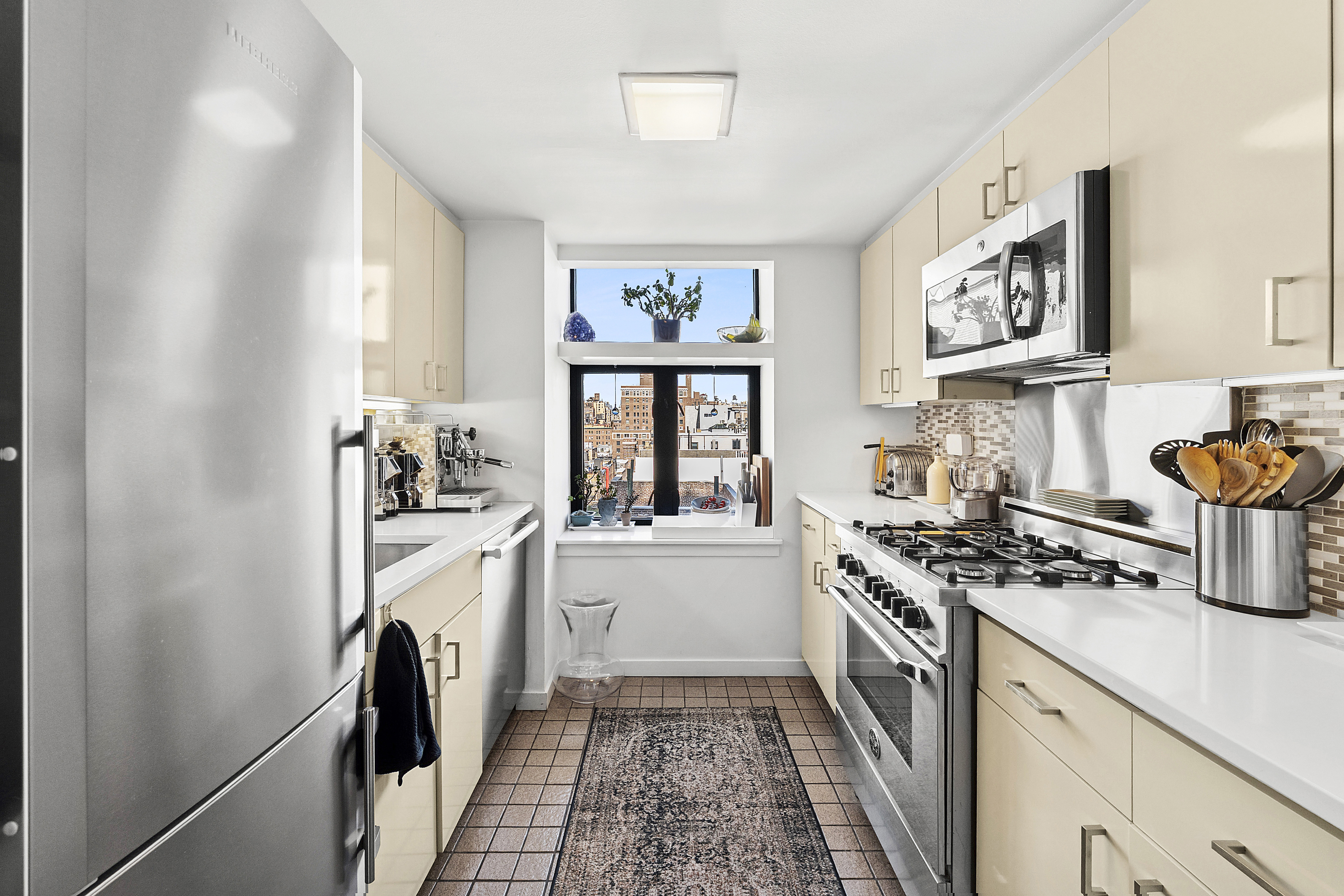 135 West 70th Street, Unit 8A Manhattan, NY 10023 - Photo 6 of 14 a kitchen with stainless steel appliances hardwood floor and a window