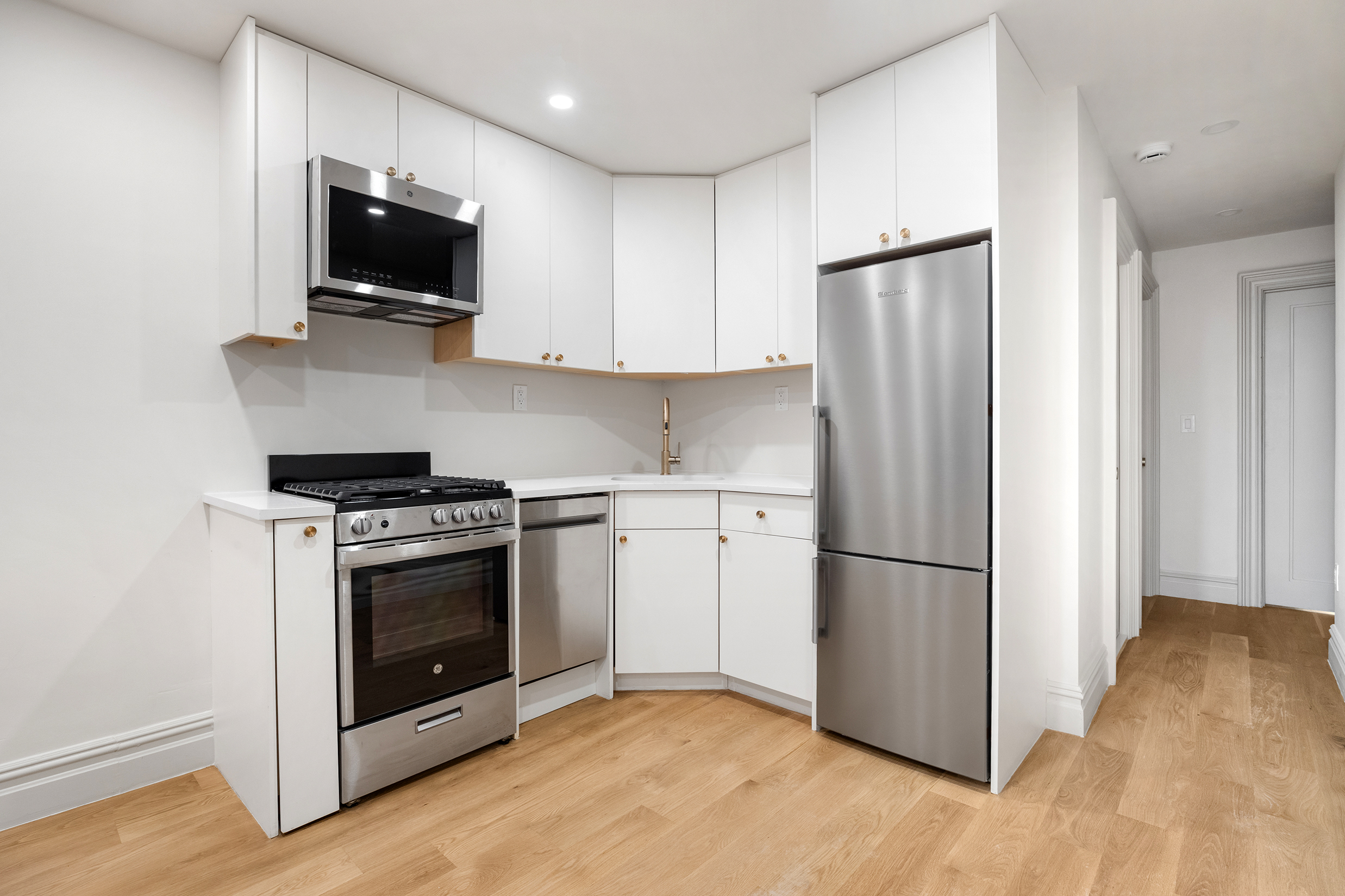 306 Halsey Street Brooklyn, NY 11216 - Photo 3 of 10 a kitchen with a refrigerator stove and microwave