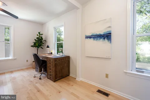 a view of a workspace with furniture and a window